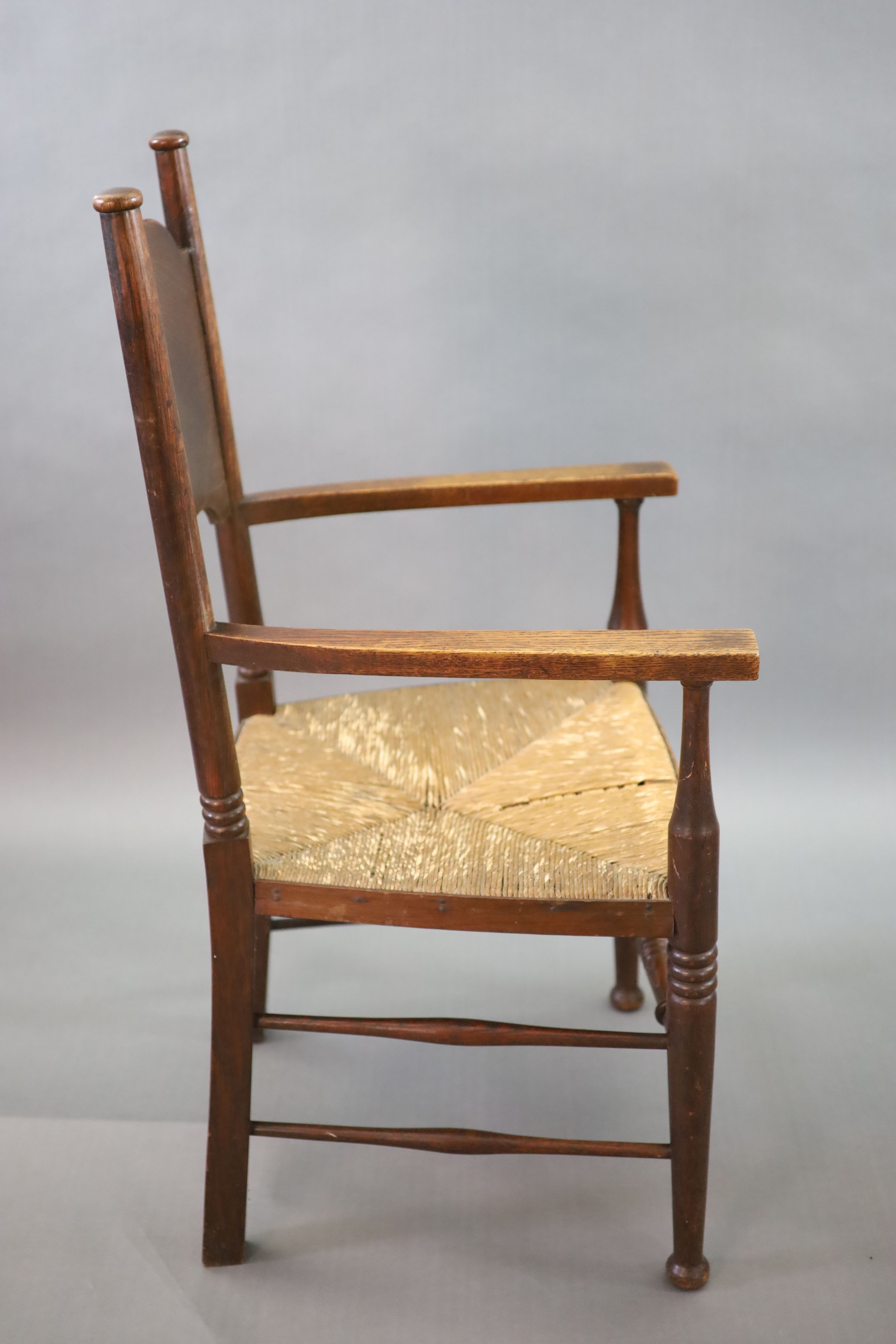 A set of six oak chairs, including a pair of carvers, in the Glasgow School manner by William Birch, High Wycombe, carvers W.58cm D.54cm H.109cm